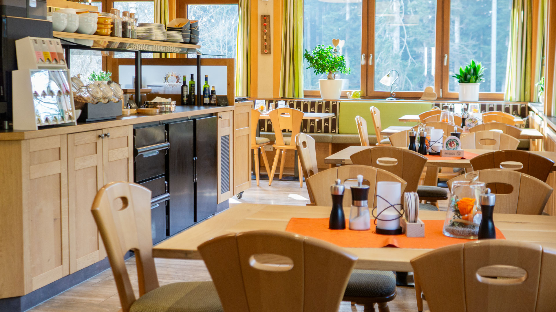 Blick in den großen Saal, im linken Bildbereich befindet sich das Frühstücksbuffet, rechts ist eine Reihe von Tischen zu sehen