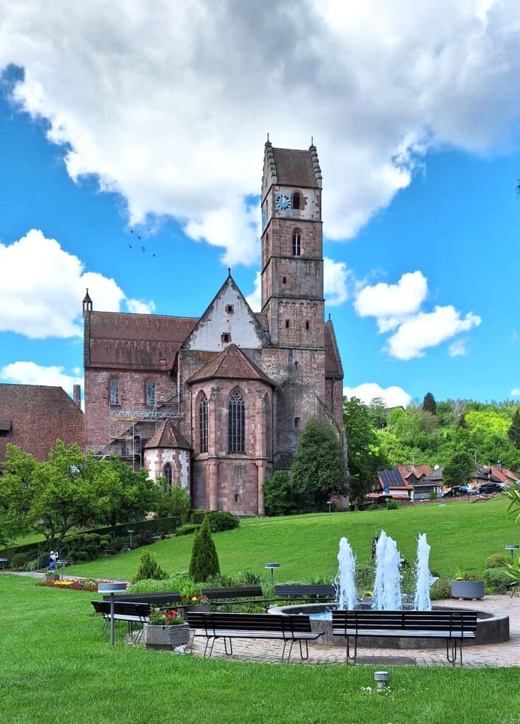 Das Kloster Alpirsbach vom Klostergarten aus gesehen. Im Vordergrund befindet sich ein Springbrunnen