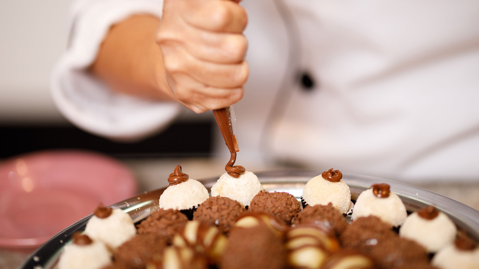 Ein Teller mit Pralinen, die mit einer Schokoladenhaube dekoriert werden